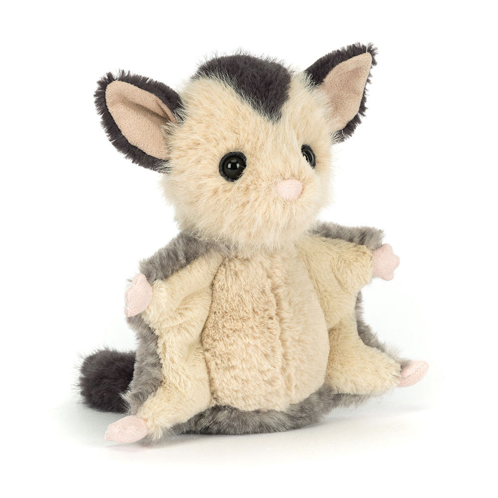 A front view of a plush sugar glider toy with soft cream and grey fur, large embroidered eyes, and outstretched arms and legs.