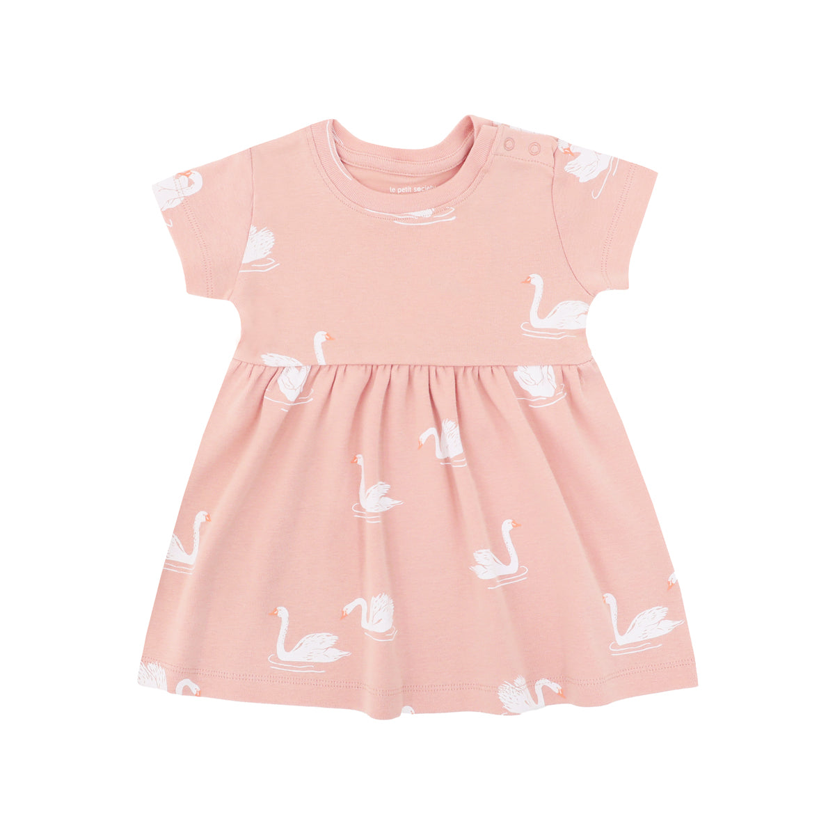 A peach-coloured, girl's organic dress adorned with a print of swans from Le Petit Society.