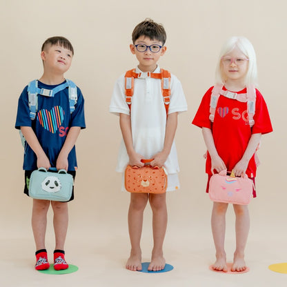 Three primary school kids carrying the Explorer pencil cases in animal prints.