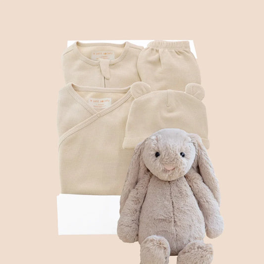 A baby welcome gift set in mocha brown by Le Petit Society, consisting of an organic baby essentials set in beige, a beige bunny by Jellycat and a signature gift box.