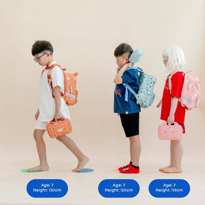 Three primary school kids carrying school bags and pencil cases from Le Petit Society.