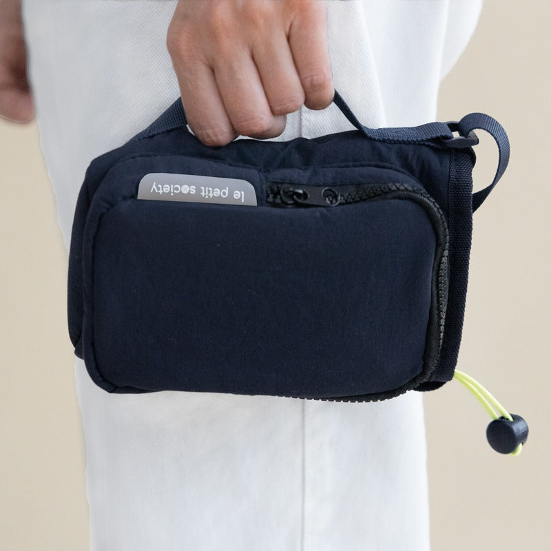 A hand carrying a water bottle bag with a side handle
