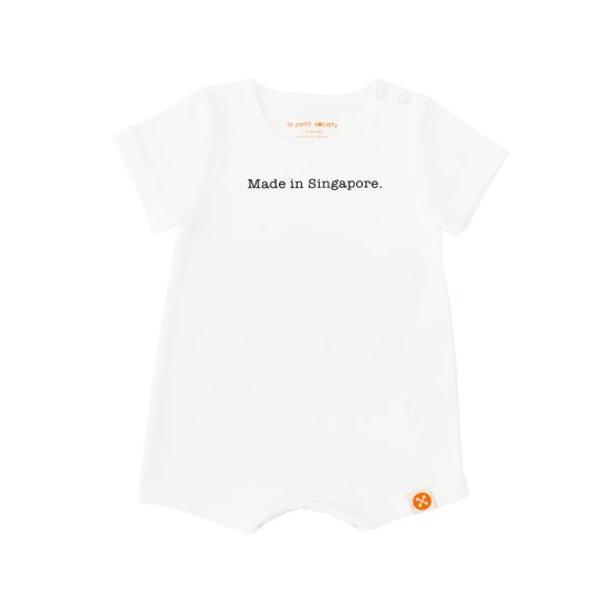 A simple white baby romper from Le Petit Society with a text at the front that says, 
