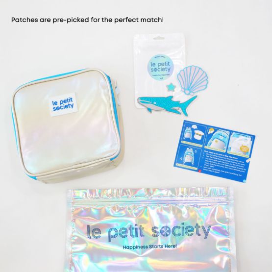An iridescent, blue and silver thermal lunch bag and personalisable ocean-themed sticker patches from Le Petit Society's customisable party pack.