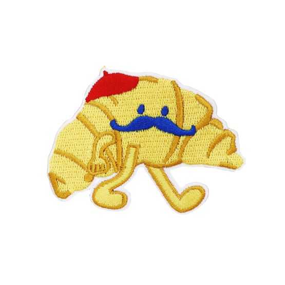 A croissant velcro patch with a moustache and a red beret, from Le Petit Society.