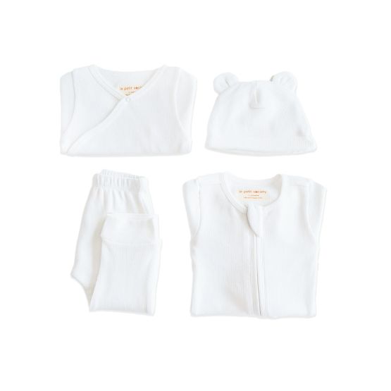 A baby organic essentials set in white by Le Petit Society, consisting of a zip sleepsuit, kimono romper, leggings and bear hat.