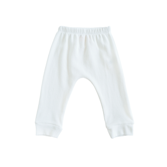 A pair of organic baby leggings in white by Le Petit Society.

