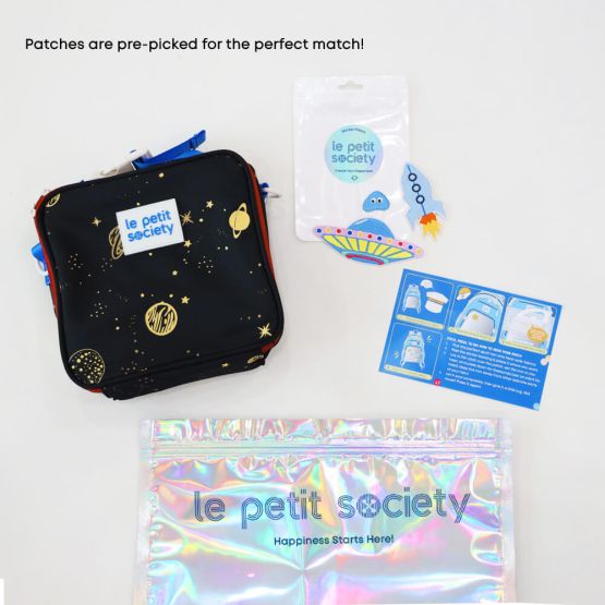 A black thermal lunch bag with a planet print and space-themed sticker patches for personalisation from Le Petit Society customisable party pack.